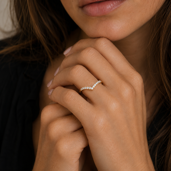 Close-up of a hand wearing a diamond ring with blurred background