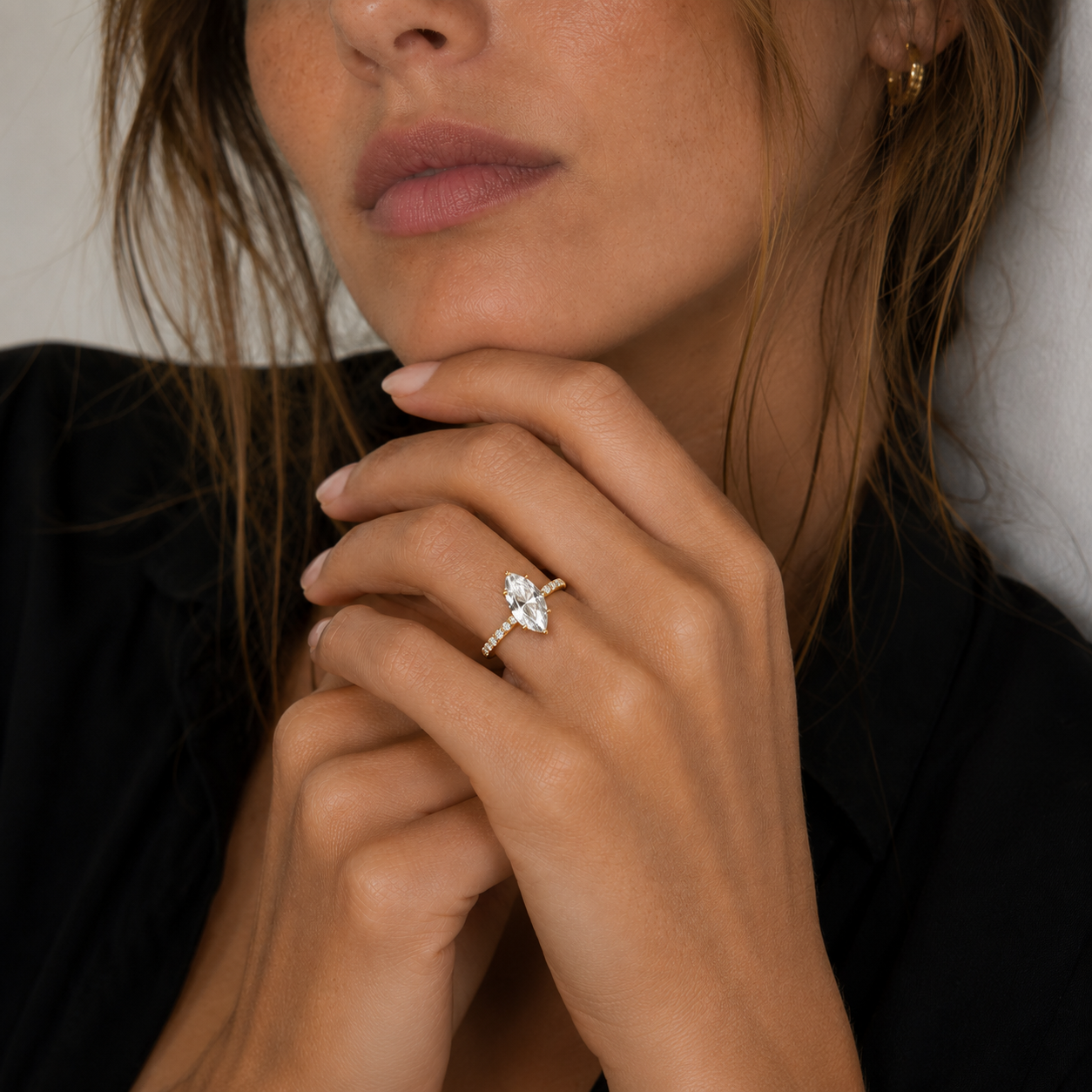 Close-up of a woman's hand wearing a diamond ring with a blurred background
