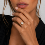 Close-up of a hand wearing a diamond ring with a blurred background