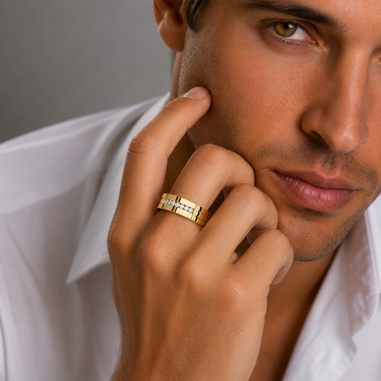 Man wearing a gold ring with a gray background