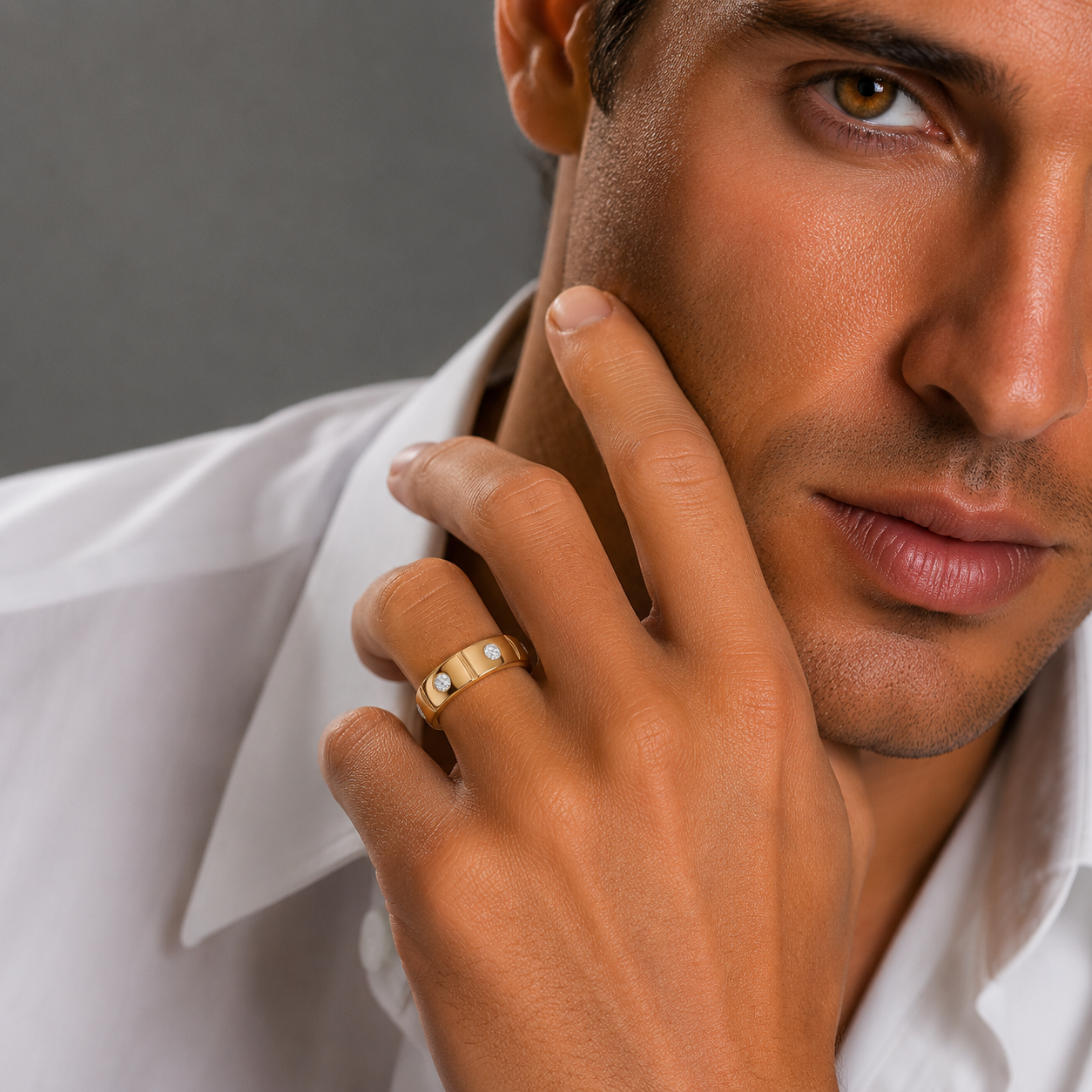 Man wearing a gold ring with a gray background