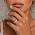 Close-up of a woman's hand wearing a diamond ring with a blurred background