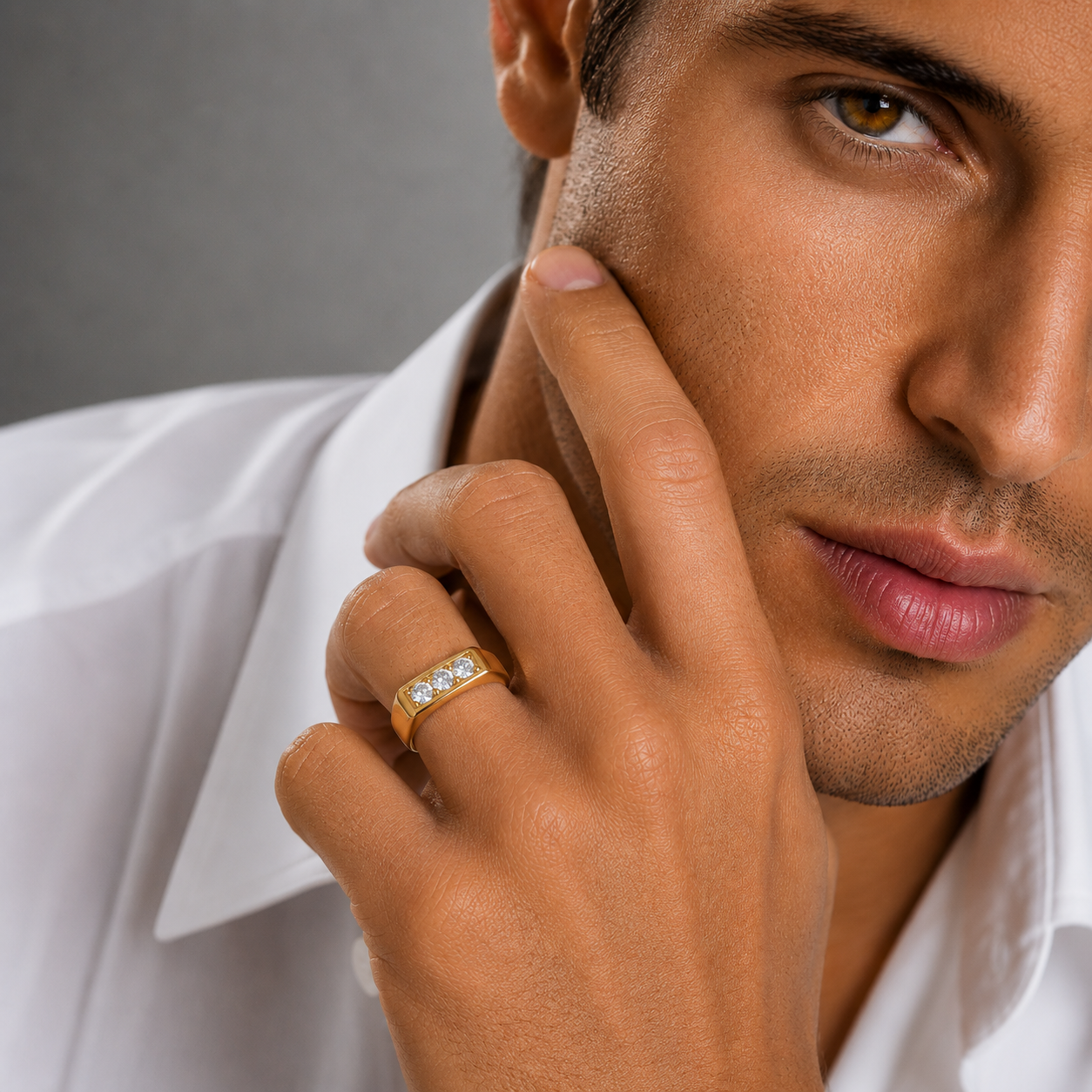 Man wearing a gold ring with a gray background
