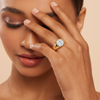 Woman wearing a gold ring with a diamond on a beige background