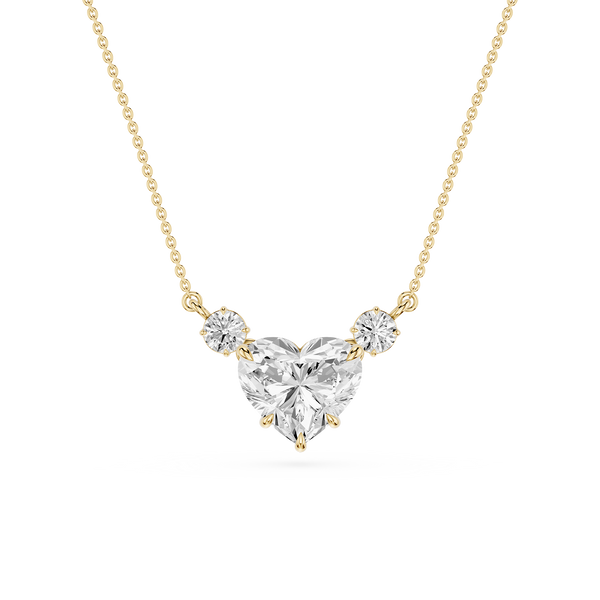A yellow gold necklace featuring a heart-shaped diamond pendant with two smaller round diamonds on either side, set against a plain white background.