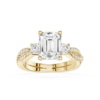 Gold ring with a large emerald-cut diamond and smaller diamonds on a white background