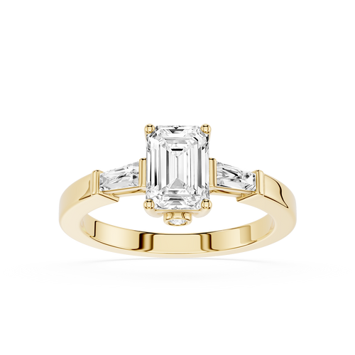 Gold ring with emerald-cut diamond and baguette side stones on a white background