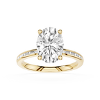 A yellow gold engagement ring featuring a large oval-cut center diamond in a four-prong setting, with a shank paved with small round diamonds, shown on a plain white background.