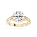 A yellow gold engagement ring featuring a large round-cut diamond center stone and smaller diamonds set along the shoulders, shown on a clean white background.