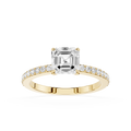 An emerald-cut diamond engagement ring in yellow gold, featuring a square center stone and a pavé-set diamond band, shown on a plain white background.