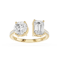 A yellow gold split-shank ring featuring a round brilliant-cut diamond on one side and an emerald-cut diamond on the other, with small pavé diamonds along the band, set against a plain white background.