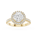 A yellow gold halo ring featuring a round-cut center diamond surrounded by a double halo of smaller diamonds, with a shank paved with small diamonds, shown on a white background.